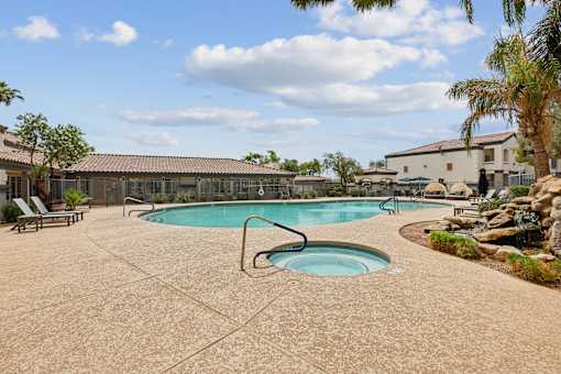 A large outdoor swimming pool with a hot tub in the middle.