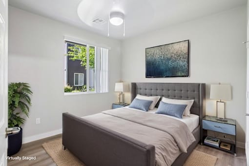 A bedroom with a large bed and a painting on the wall.
