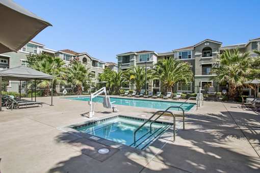 A swimming pool in a sunny outdoor pool area.