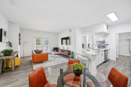A modern living room with a dining table and chairs.