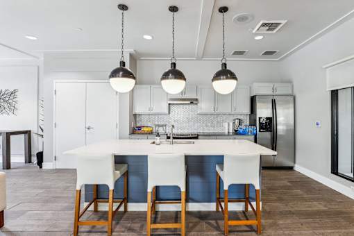 a kitchen with a large island with four chairs in front of it