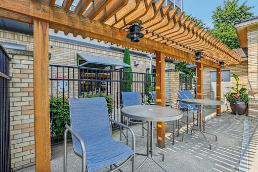 a patio with tables and chairs and a pergola