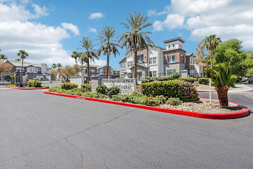 an empty street with palm trees in front of houses