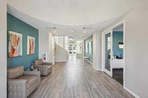 a long hallway with couches and a mirror on the wall