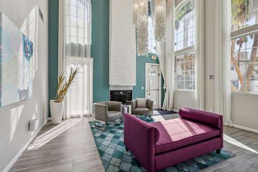 a living room with a purple couch and chairs and a fireplace