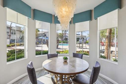 a dining room with a table and chairs and windows