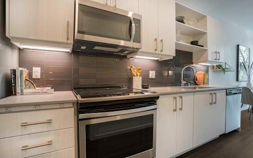 a kitchen with white cabinets and a stove and a microwave