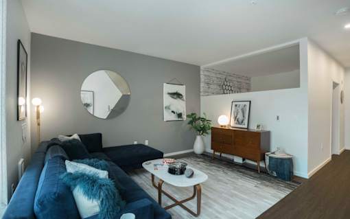 a living room with a blue couch and a white coffee table