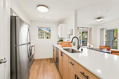 A kitchen with wooden floors and white countertops.