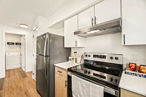A modern kitchen with a stainless steel refrigerator and oven.