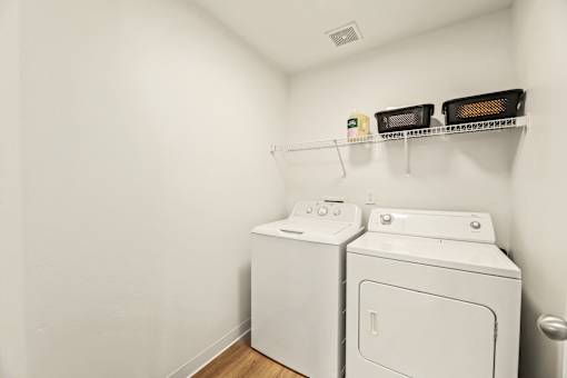 A white washing machine and dryer in a small laundry room.