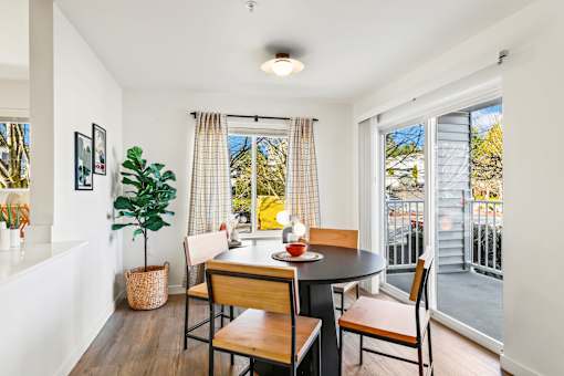 A dining room with a table and chairs.