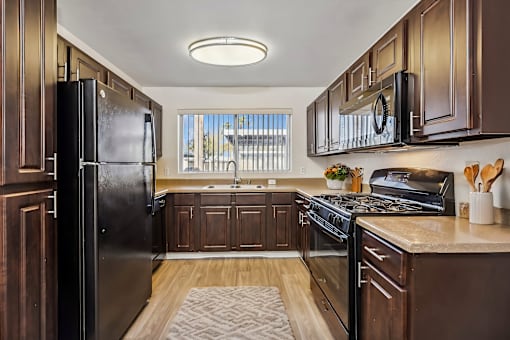 a kitchen with black appliances and wooden cabinets