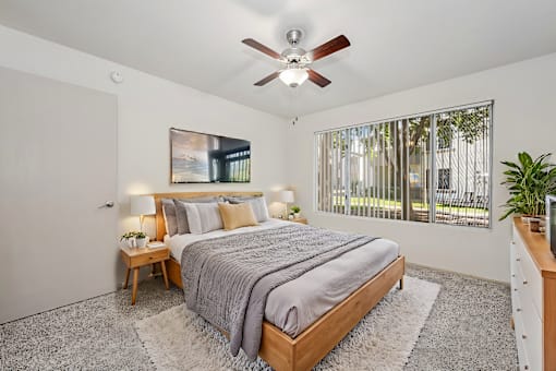 a bedroom with a bed and a ceiling fan