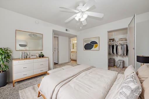 a bedroom with a large bed and a ceiling fan