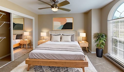 a bedroom with a large bed and a ceiling fan