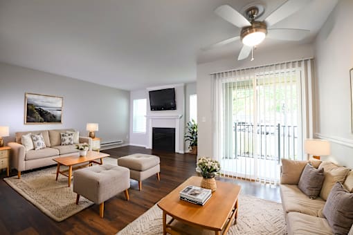 a living room with couches and a table and a ceiling fan
