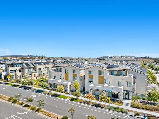 A row of modern houses with a road in front of them.
