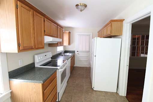 a kitchen with wooden cabinets and a white refrigerator