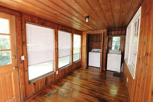 a small room with wood floors and a kitchen
