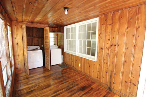 a small cabin with wood floors and a window
