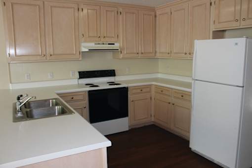 a kitchen with white appliances and wooden cabinets