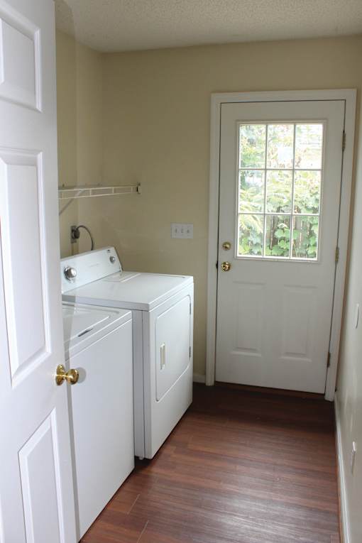 a laundry room with a washer and a white door