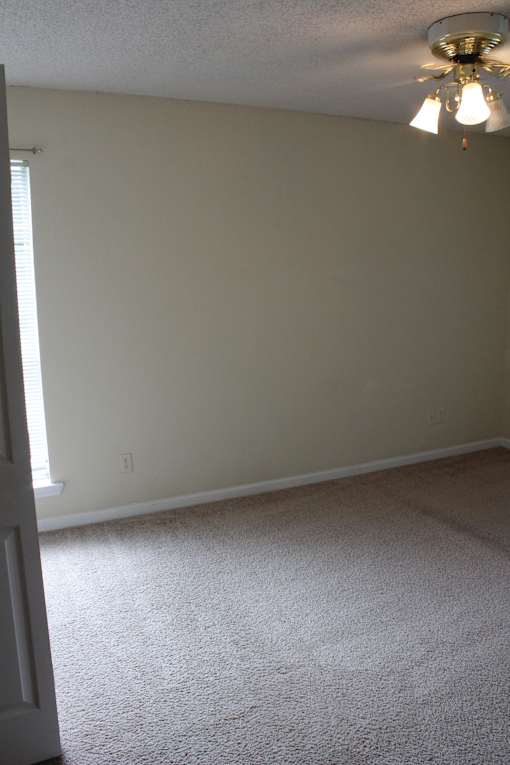 a room with a white wall and a ceiling fan