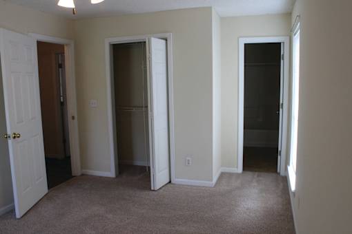 an empty room with three doors and a carpeted floor