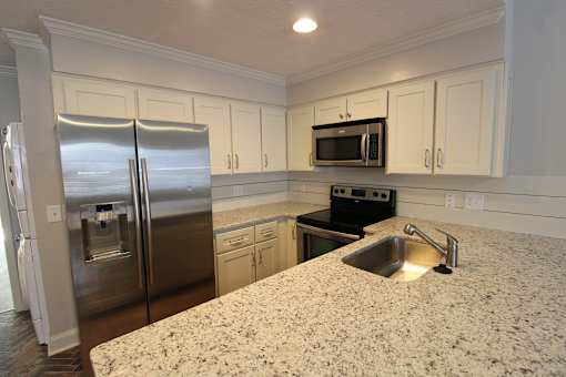 a kitchen with granite counter tops and stainless steel appliances
