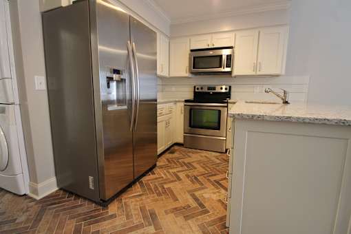 a kitchen with stainless steel appliances and a wooden floor