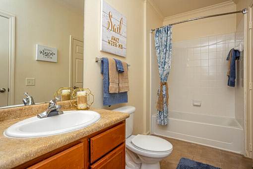 A bathroom with a sink, toilet, and shower.