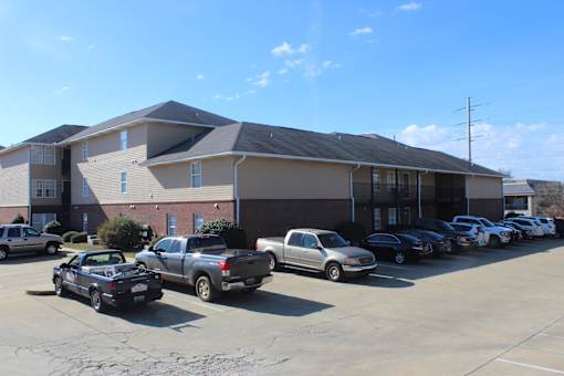 the front of a building with cars parked in a parking lot