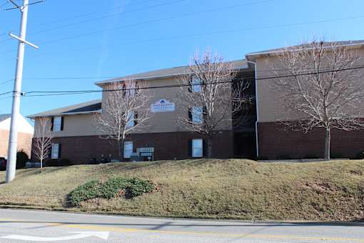 a large brick building with a hill in front of it