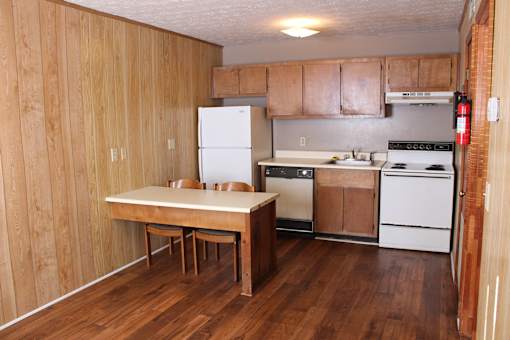 a kitchen with a table and a stove and a refrigerator