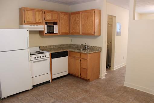 a kitchen with white appliances and wooden cabinets