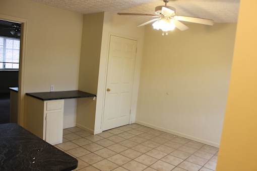 a kitchen with a door and a ceiling fan