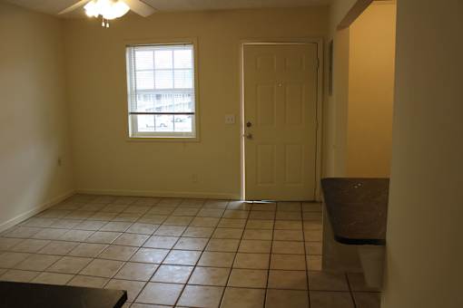 an empty living room with a door and a window