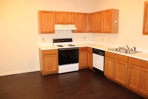 a kitchen with wooden cabinets and a stove and a sink