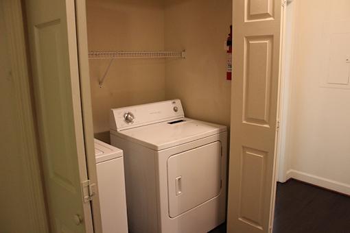 an empty laundry room with a washer and dryer in it