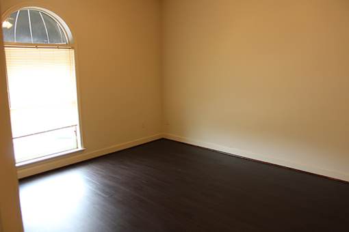 an empty room with wooden floors and a window