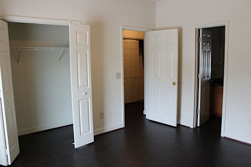 an empty living room with two doors and a closet