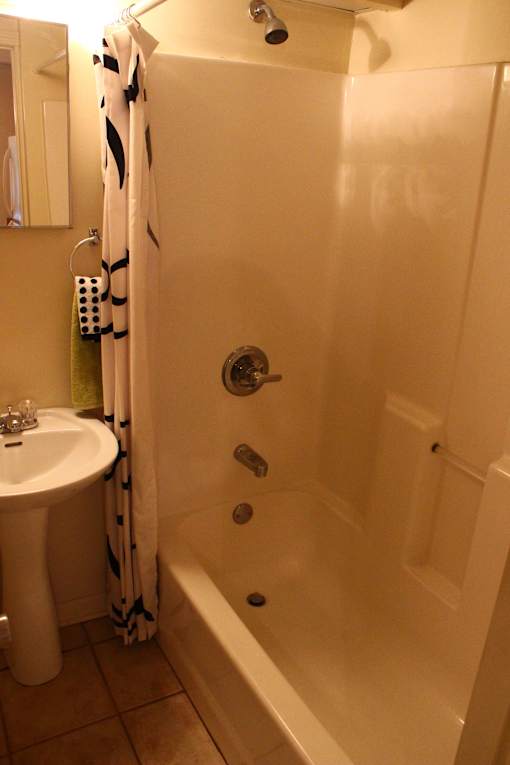 A white bathroom with a shower curtain and a white sink.
