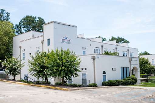 A white building with a blue sign on it.