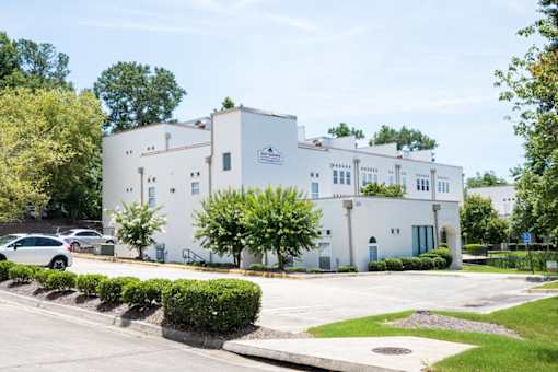 A white building with a blue door and a sign on the front.