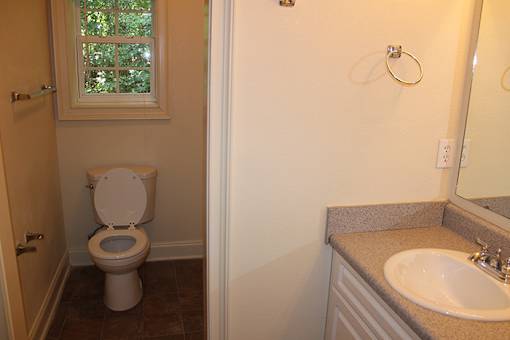 a bathroom with a toilet and a sink and a window