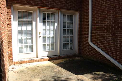 a door with white shutters on a brick building