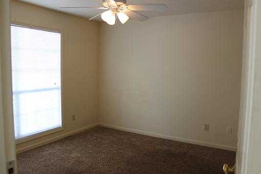 a bedroom with a ceiling fan and a window