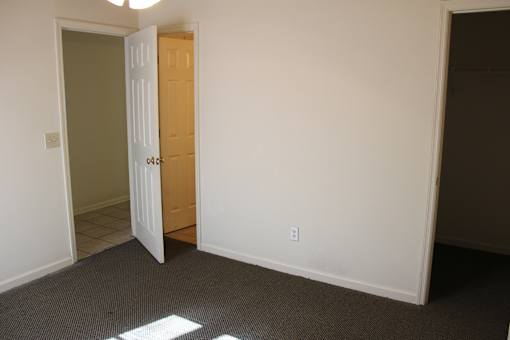 a bedroom with a door and a closet and a door to a bathroom