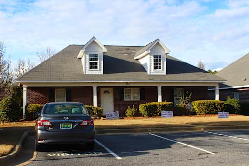 a car parked in a parking lot in front of a house